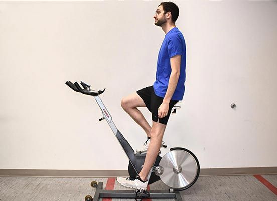 En man som demonstrerar sittposition på en modern motionscykel.